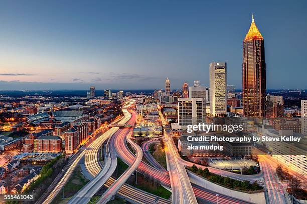 The midtown skyline and interstate highway system as it merges into downtown Atlanta in the late evening. Viewable are great light trails from the traffic on the highways, Georgia Tech University, and various midtown skyscrapers.
