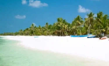 Agatti Island, Lakshadweep – pristine white sandy beach with crystal-clear turquoise lagoon, swaying palm trees, and a serene tropical shoreline under a bright blue sky, perfect for a relaxing island getaway.