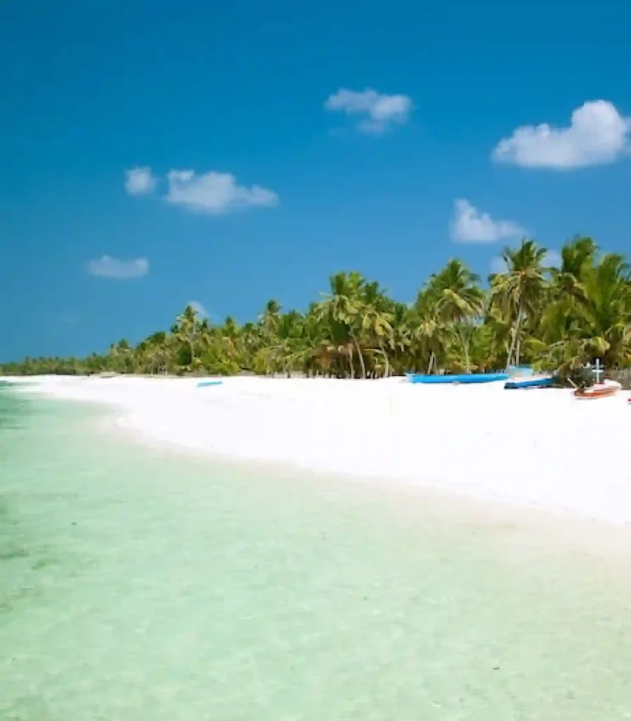 Agatti Island, Lakshadweep – pristine white sandy beach with crystal-clear turquoise lagoon, swaying palm trees, and a serene tropical shoreline under a bright blue sky, perfect for a relaxing island getaway.