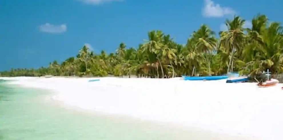 Agatti Island, Lakshadweep – pristine white sandy beach with crystal-clear turquoise lagoon, swaying palm trees, and a serene tropical shoreline under a bright blue sky, perfect for a relaxing island getaway.