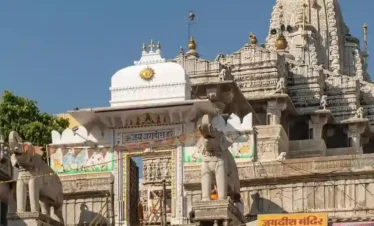 Intricately carved entrance and towering spire of Jagdish Temple with stone elephants and steps leading up in Udaipur.