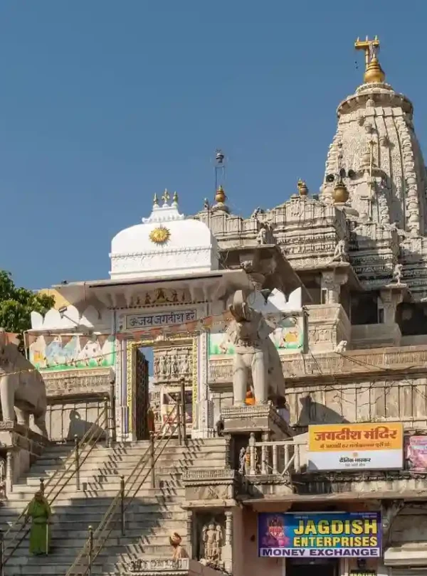 Intricately carved entrance and towering spire of Jagdish Temple with stone elephants and steps leading up in Udaipur.