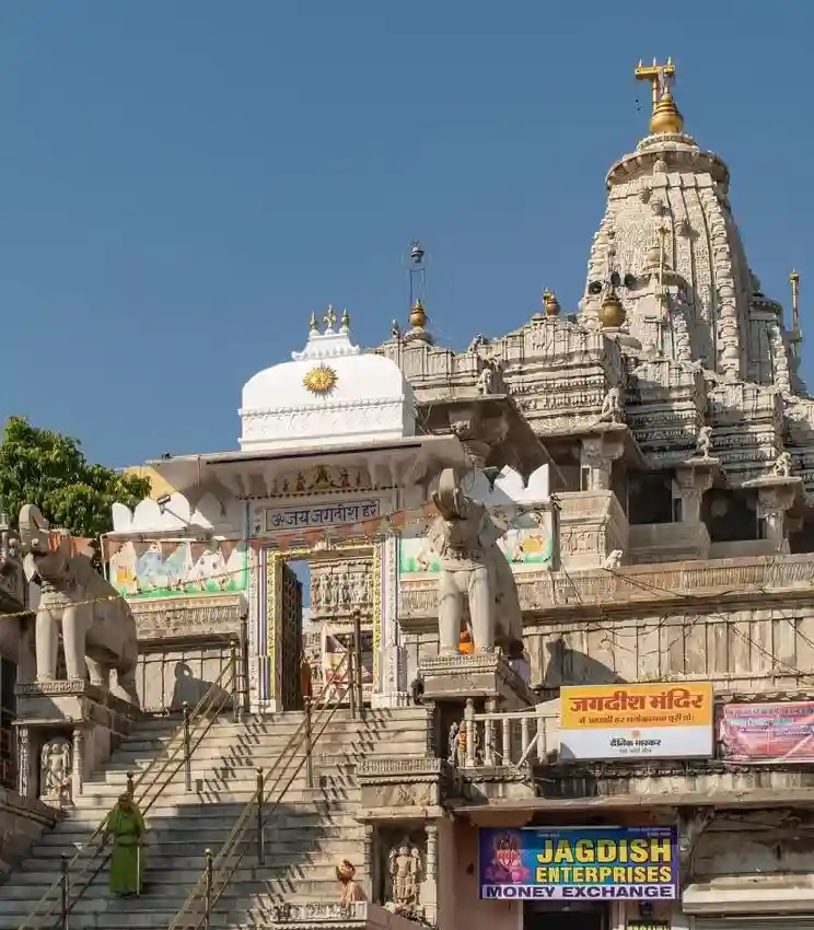 Intricately carved entrance and towering spire of Jagdish Temple with stone elephants and steps leading up in Udaipur.